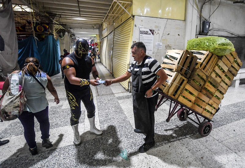 Luchadores enmascarados reparten tapabocas contra covid-19 en México