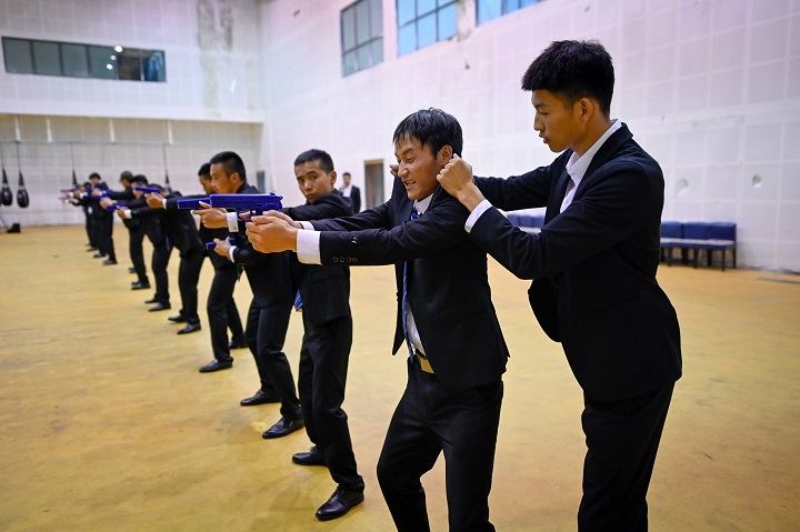 Traje, pistola y ciberseguridad en escuela china de guardaespaldas