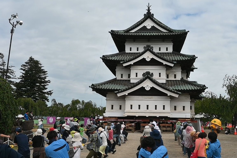 Cientos de voluntarios mueven con cuerdas una torre de 400 toneladas de un castillo en el norte de Japón